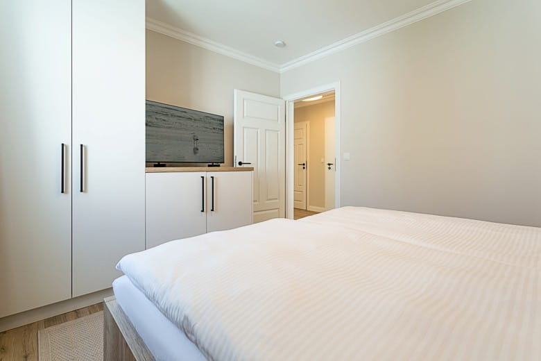 Villa Vesta Appartements 1. OG - Schlafzimmer mit Kleiderschrank und TV
